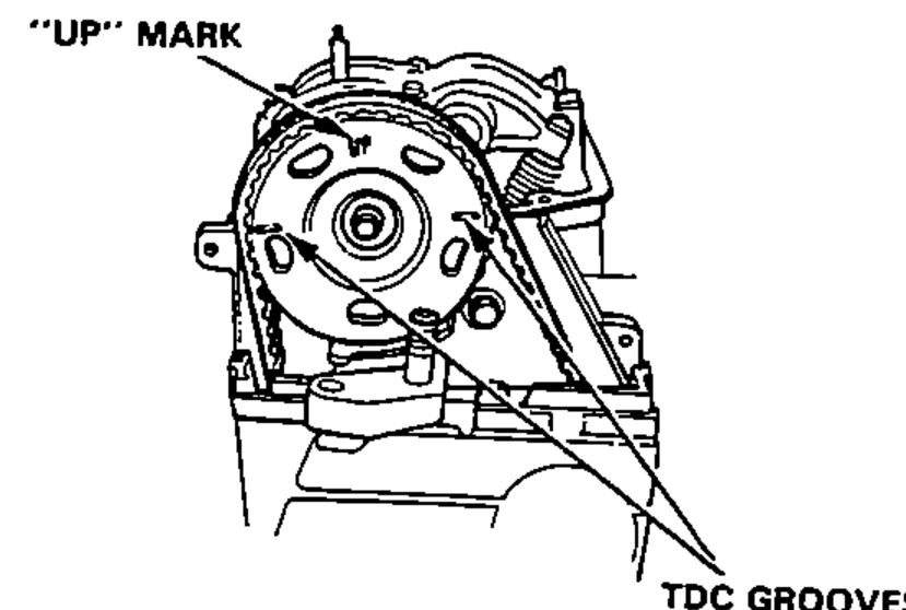 Number 1 piston at TDC: timing-belt pulley showing the "UP" MARK at top and the TDC GROOVES aligned with the cylinder head surface.
