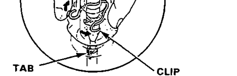 Close-up of the speedometer cable holder showing the tab and clip; do not remove the holder.