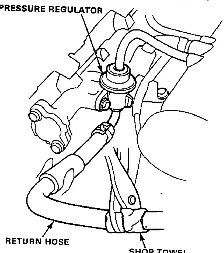 Detail of the pressure regulator and its return hose; a shop towel is shown where the return hose is pinched.