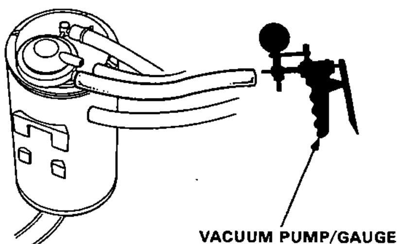 Charcoal canister with the upper vacuum hose disconnected from the "PCV" fitting and a hand-held vacuum pump/gauge connected to the "purge" fitting.