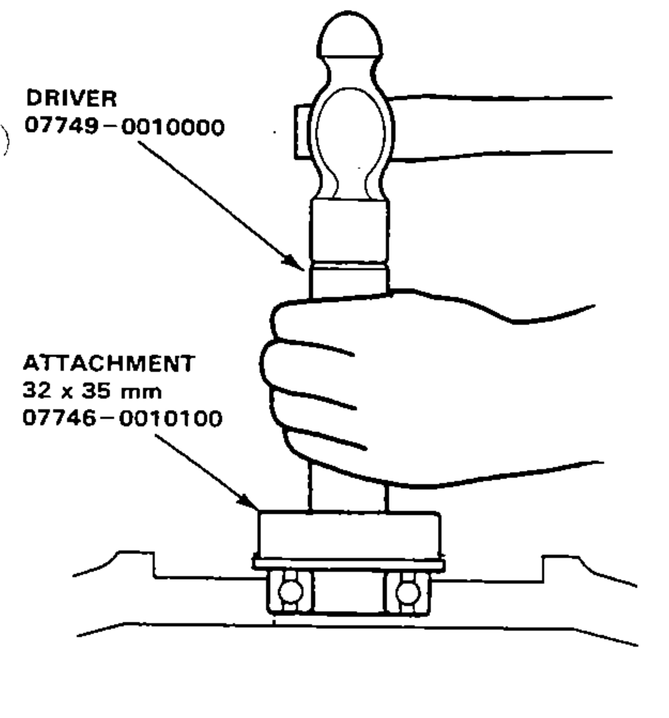Driving a new bearing into the flywheel using the Driver and Attachment special tools with a hammer.