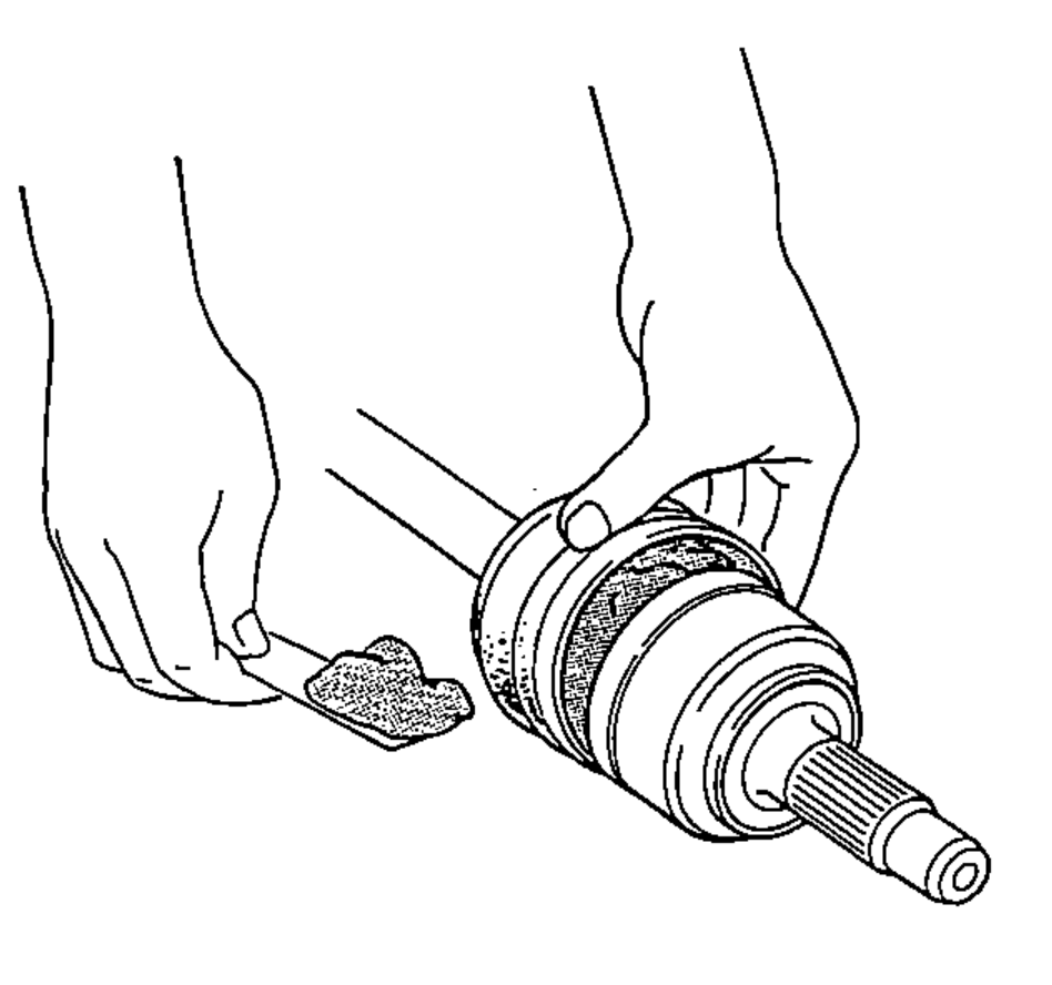 Hands packing the outboard joint boot with molybdenum disulfide grease.