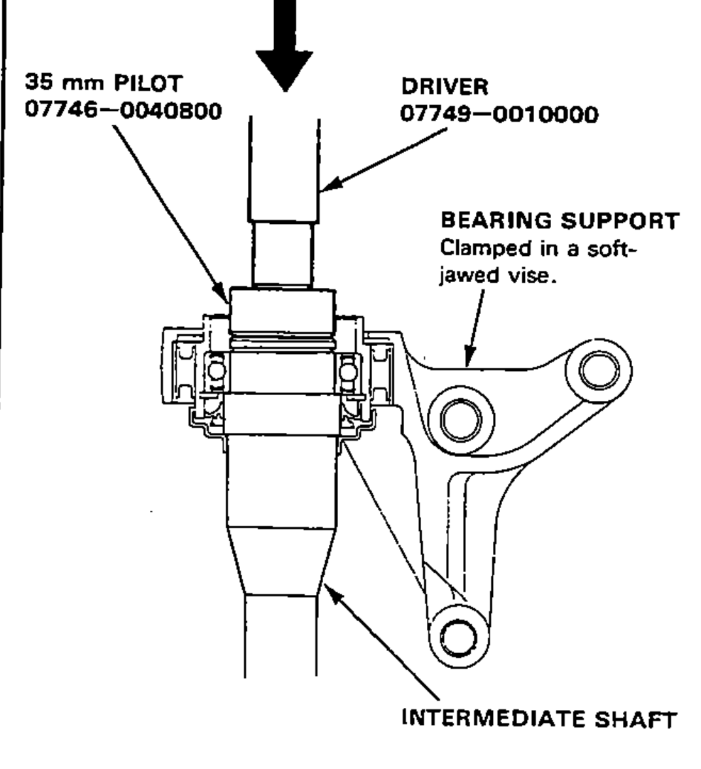 Driving the intermediate shaft out of the shaft bearing using a 35 mm pilot and driver, with the bearing support clamped in a soft-jawed vise.