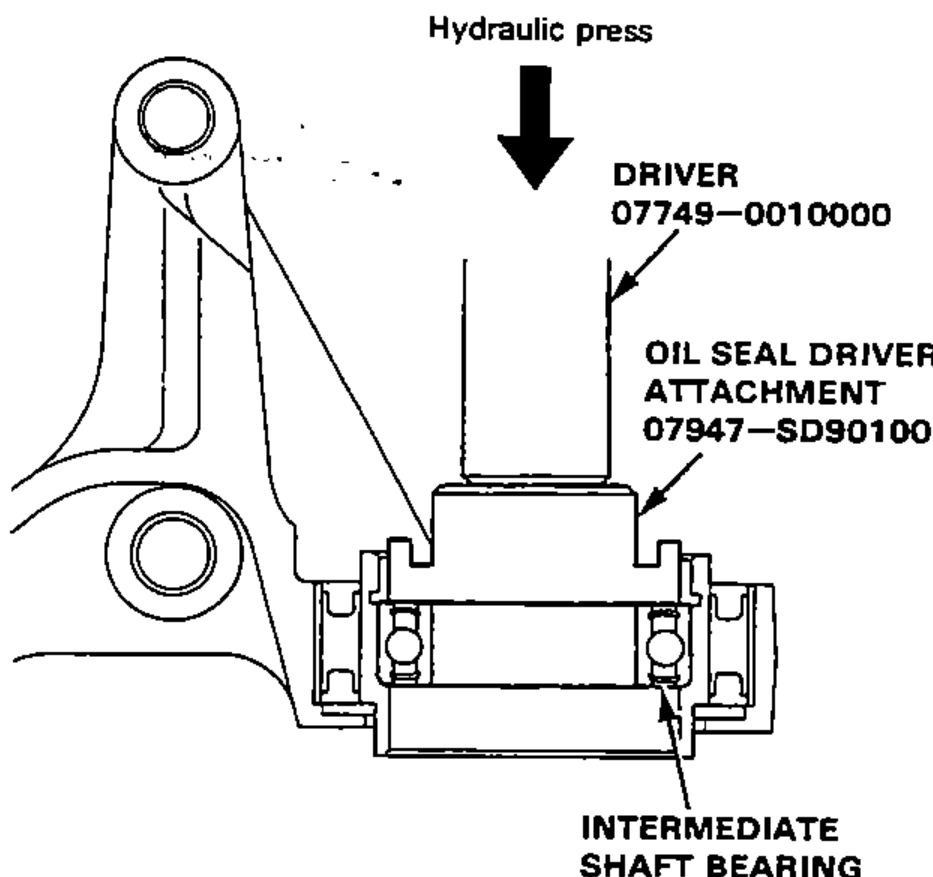 Pressing the intermediate shaft bearing into the bearing support on a hydraulic press using a driver and oil seal driver attachment.