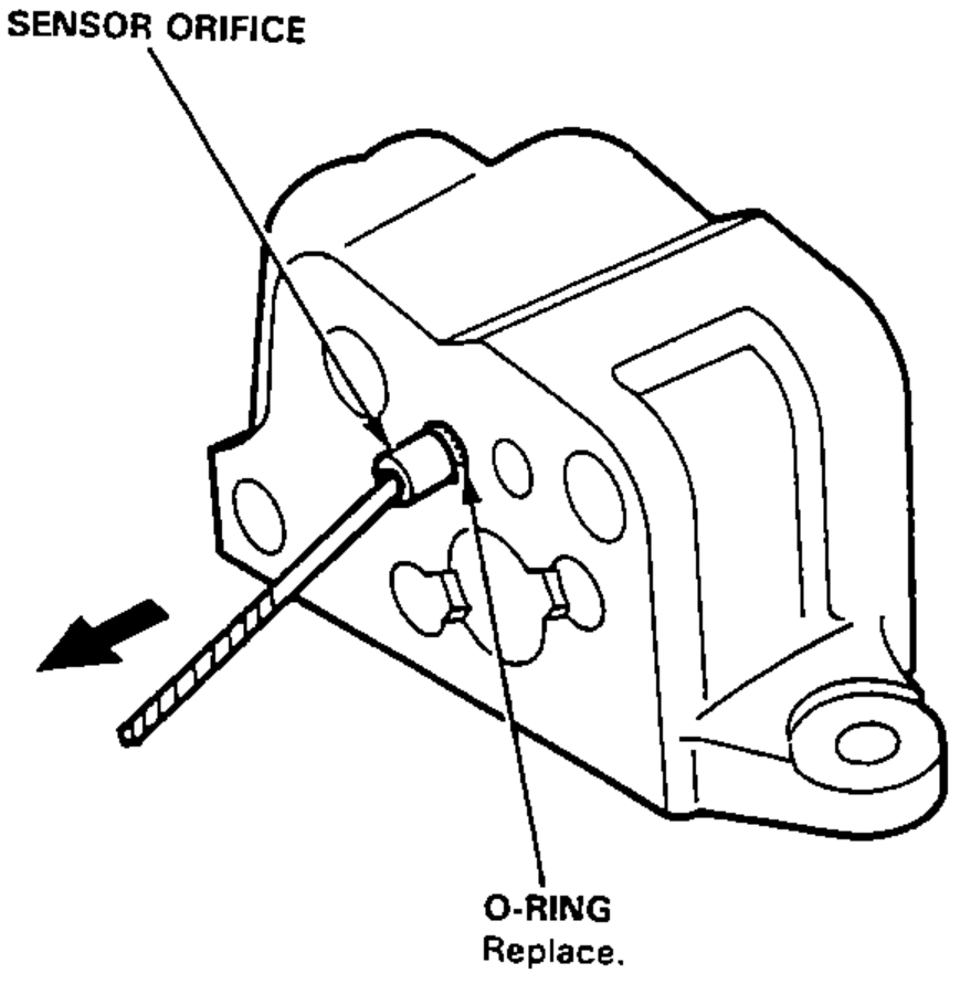 Valve body with a drill bit being used to push out the sensor orifice and O-ring; arrow shows the direction of removal.