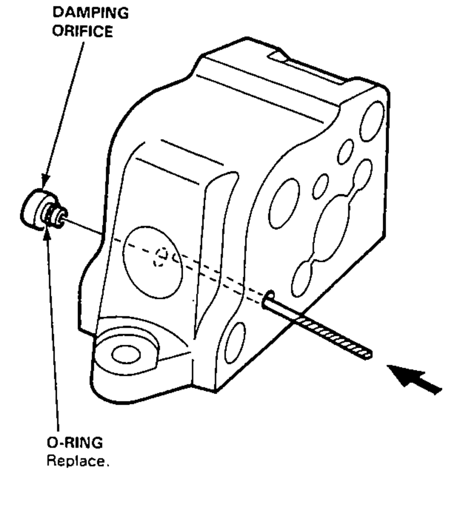 Valve body with a drill bit being used to push the damping orifice and O-ring out; arrow shows the direction of removal.