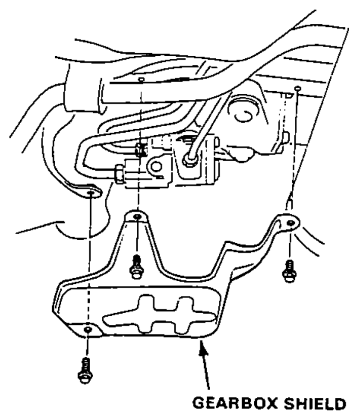 Underbody view showing the gearbox shield being installed with its mounting bolts.