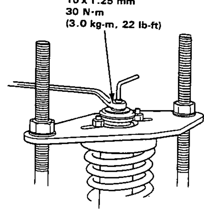 Damper shaft held on the spring compressor plate while tightening the 10 mm self-locking nut.