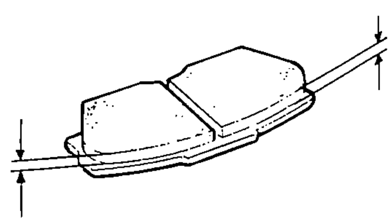 Side view of a brake pad with vertical dimension arrows indicating measurement of the pad lining thickness with a vernier caliper.