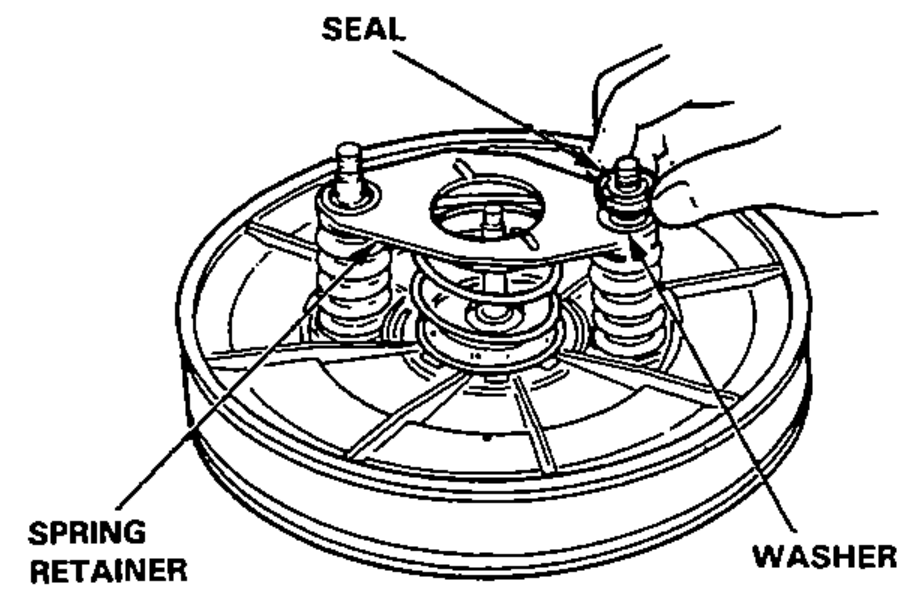 Hand installing the washers and seals on the through bolts of the booster housing, showing seal, spring retainer and washer locations.