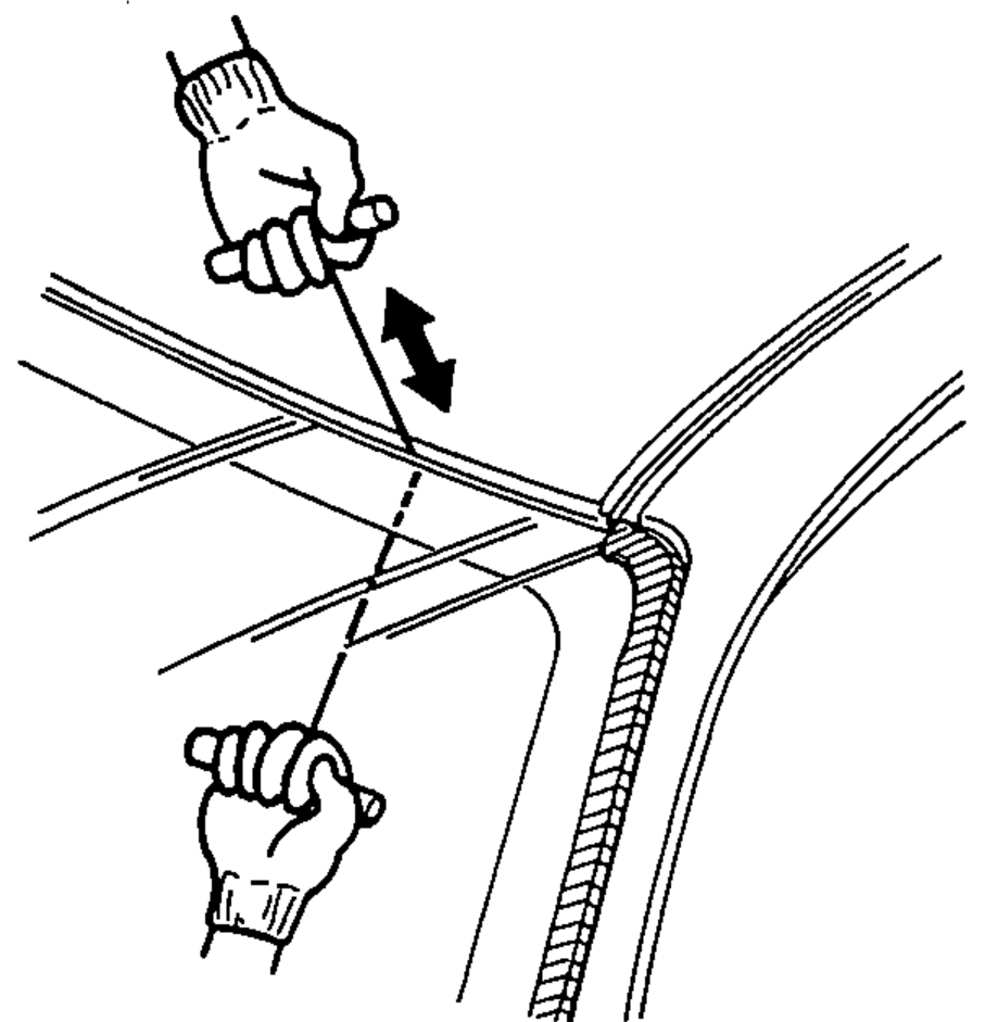 Two hands, one inside and one outside the car, pulling the piano wire back and forth in a sawing motion to cut the adhesive around the windshield.